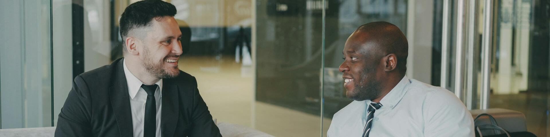 Two people facing each other, smiling. 
